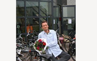 IM Manuel Bosboom smiling and holding some red flowers