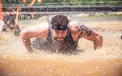 Man crawling through mud