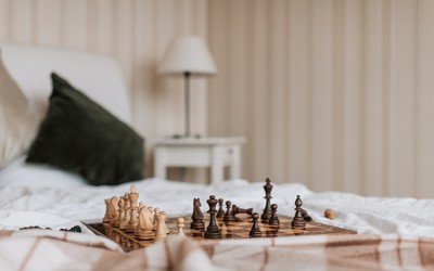 Brown Wooden Chessboard on the Bed