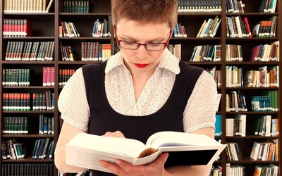 Mujer intelectual leyendo un libro en sus manos