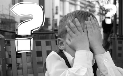 Boy with hands covering his face and big question mark next to his face