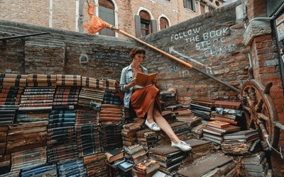 Woman standing on staircase made of books