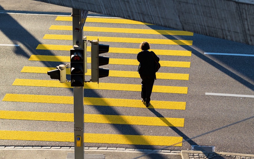 Person crossing the street on a yellow zebra crossing